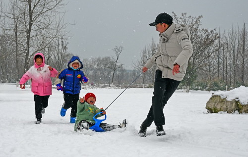 李耀民《雪趣》2024年2月4号，家长在雪中陪孩子们滑雪橇。李耀民13972223939